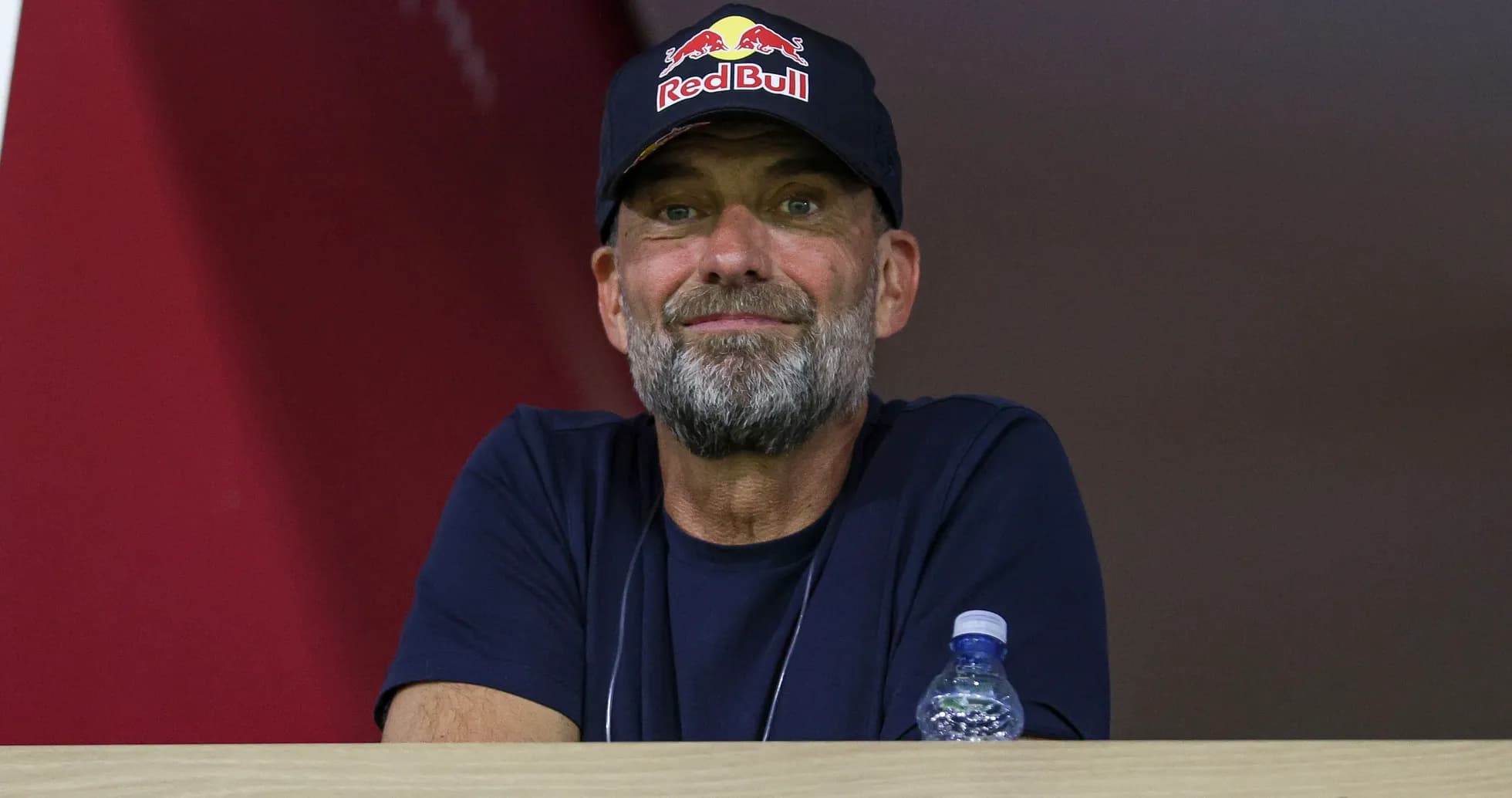Man with a beard wearing a Red Bull cap