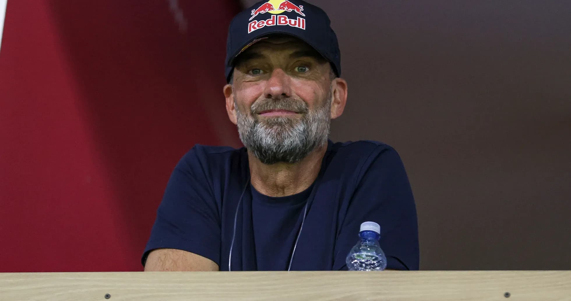 Man in a Red Bull cap watching from a balcony