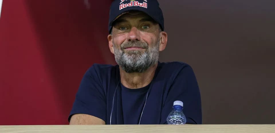 Man in a Red Bull cap watching from a balcony