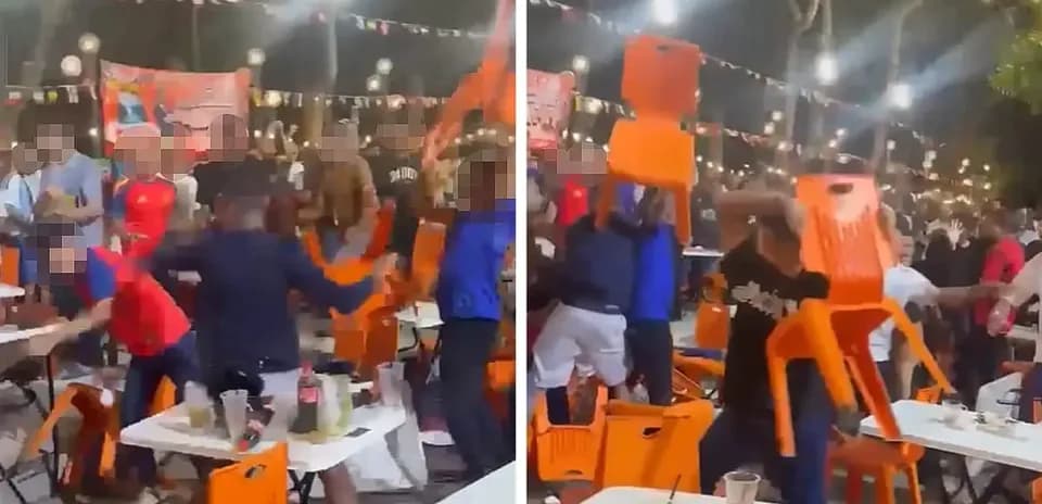 Crowd throwing chairs during an event at night