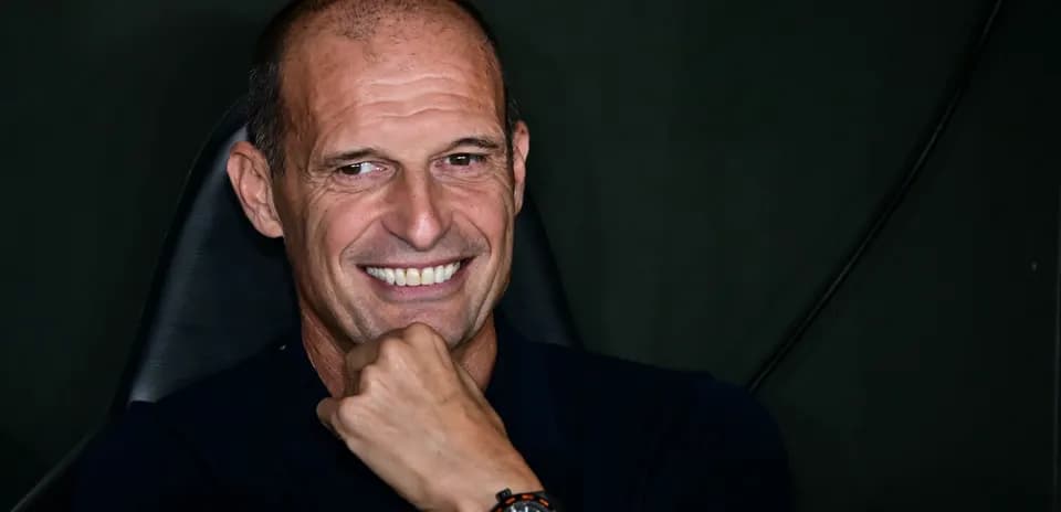 Coach smiling while seated at press conference