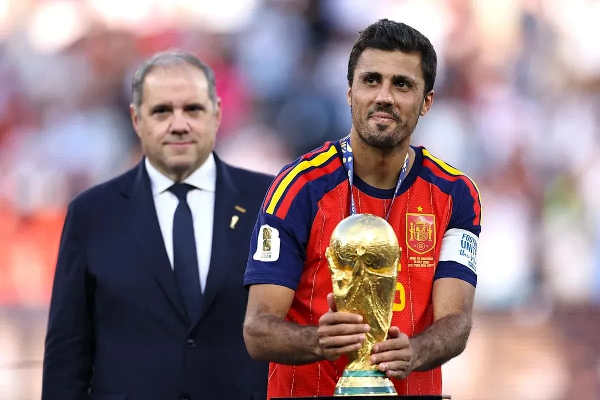 Player holding World Cup trophy with official nearby
