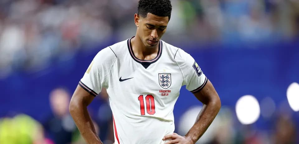Player in England jersey looking down on the field