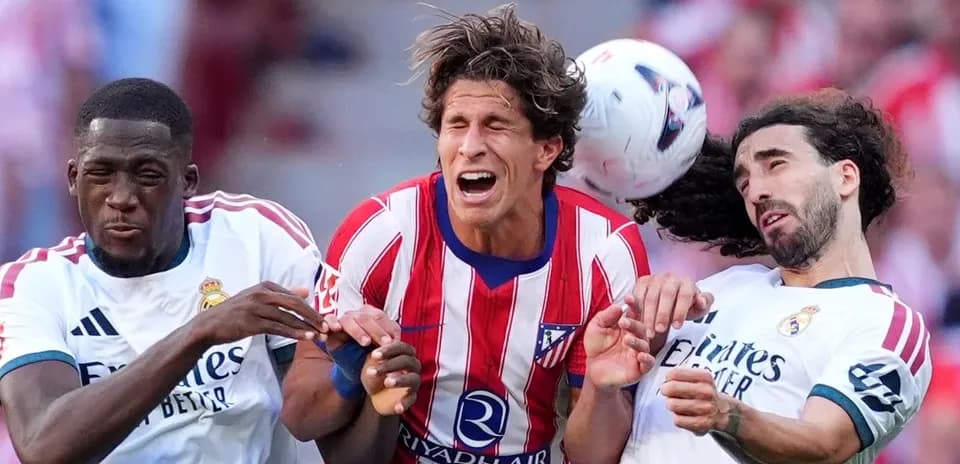 Players from Atlético and Real Madrid contesting the ball