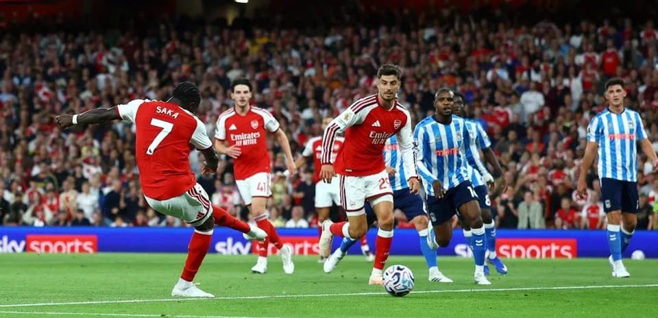 Arsenal player Saka dribbling during match against Brighton