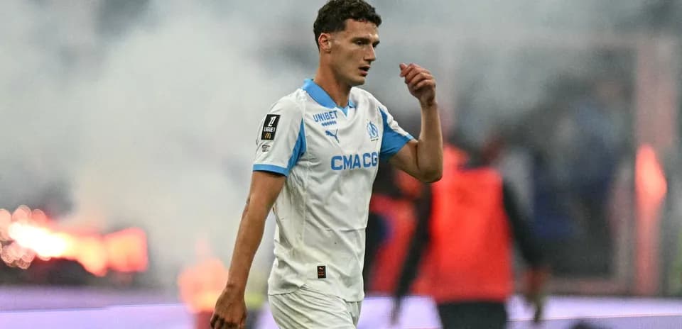 Player walking off the field with smoke in background