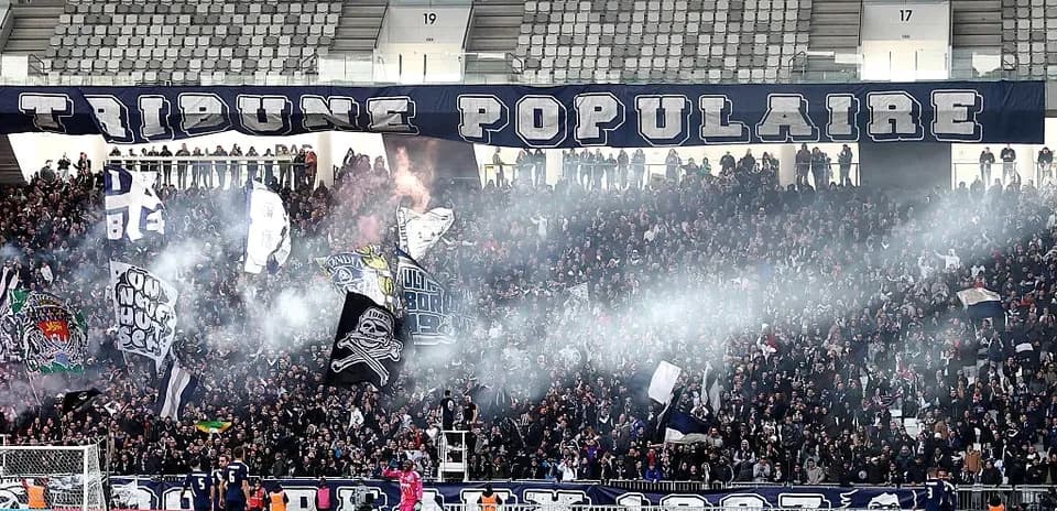 Crowd of fans with banners and smoke in stadium