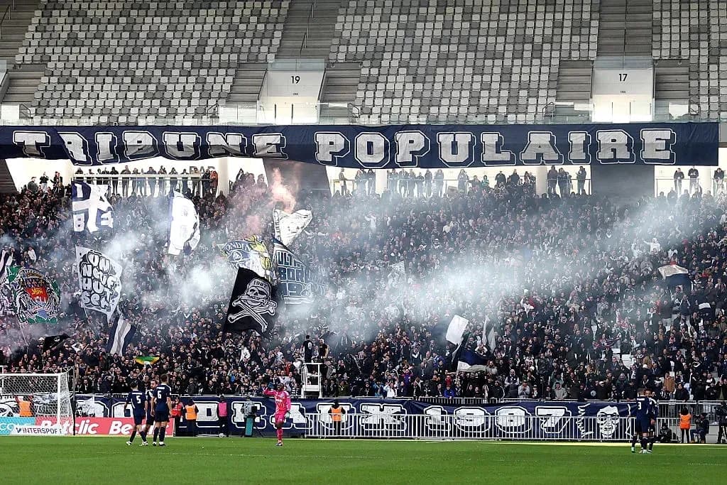 Crowd of fans with banners and smoke in stadium