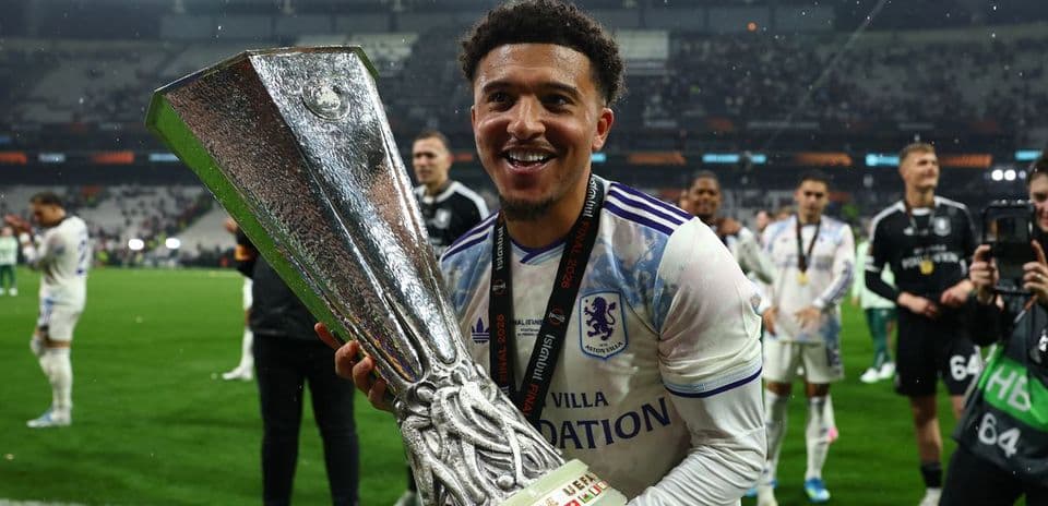 Player celebrating with UEFA trophy on the field