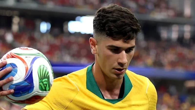 Player in yellow kit holding a soccer ball