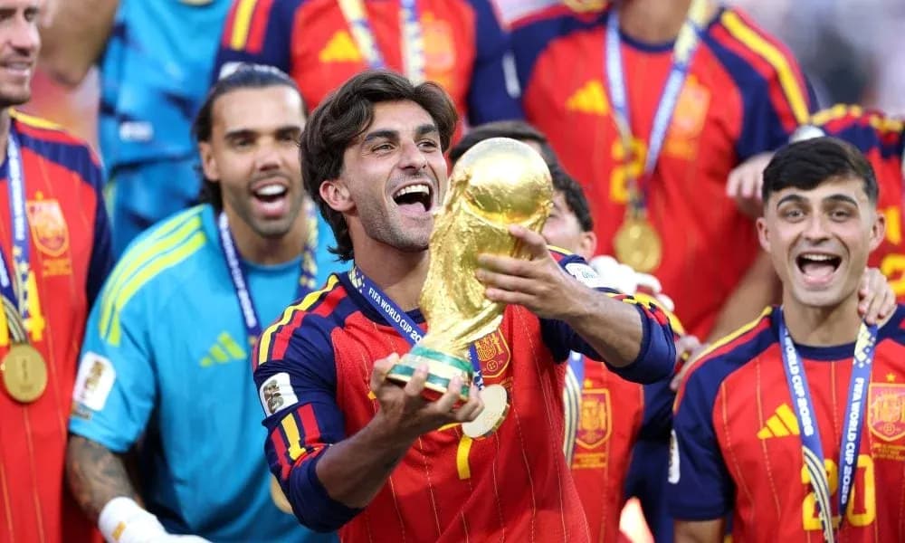 Player celebrating with FIFA World Cup trophy and teammates