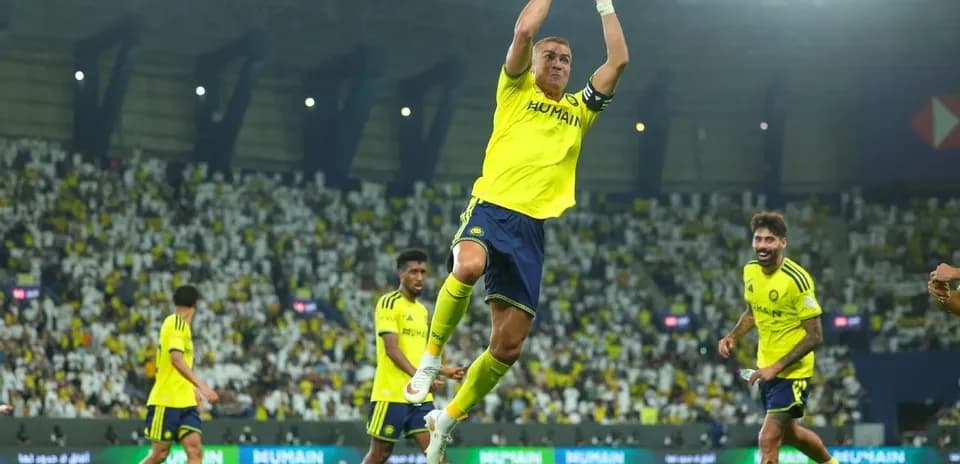 Player celebrating a goal with teammates in stadium