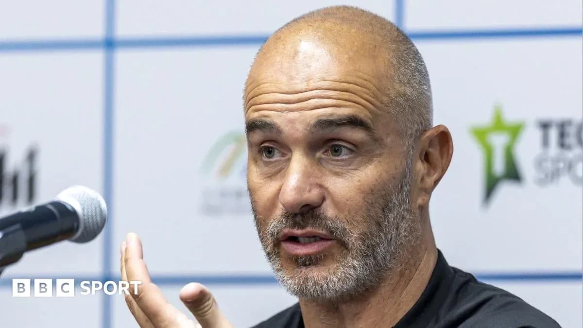 Manager speaking at press conference with microphone
