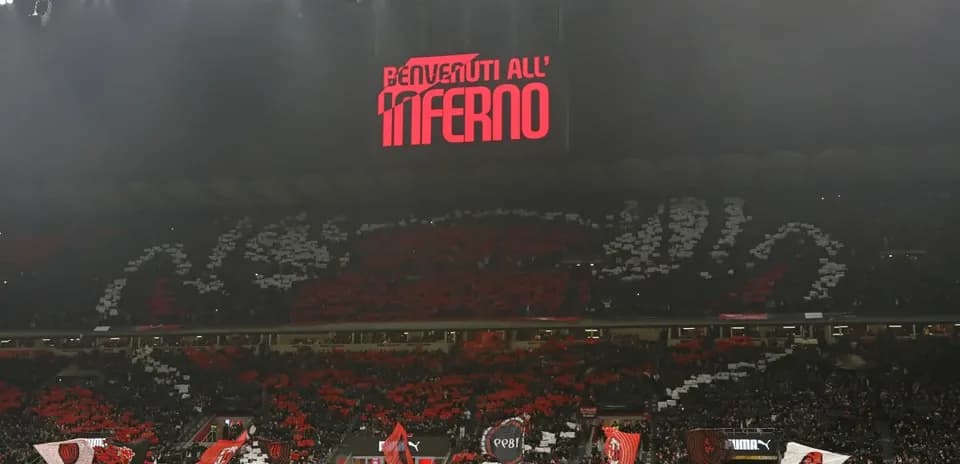 Fans displaying banners at stadium with lights on