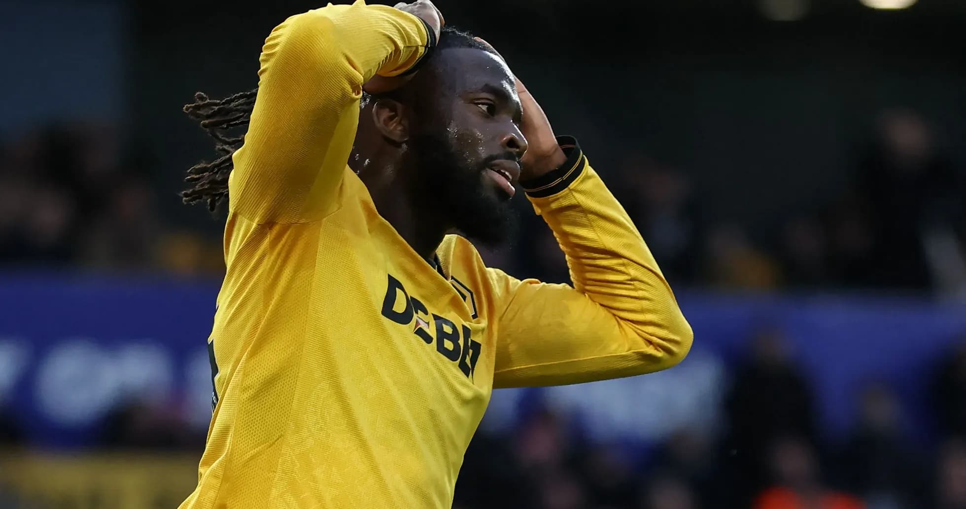 Player in yellow jersey holding head in frustration