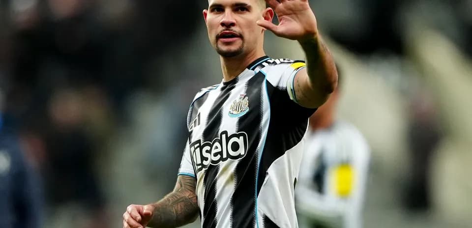 Player waving while wearing Newcastle United jersey
