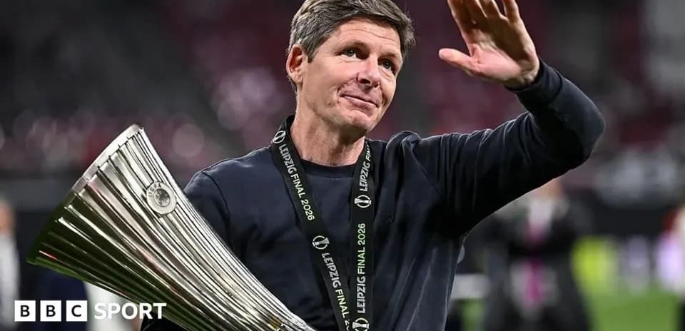 Coach holding trophy and waving to crowd