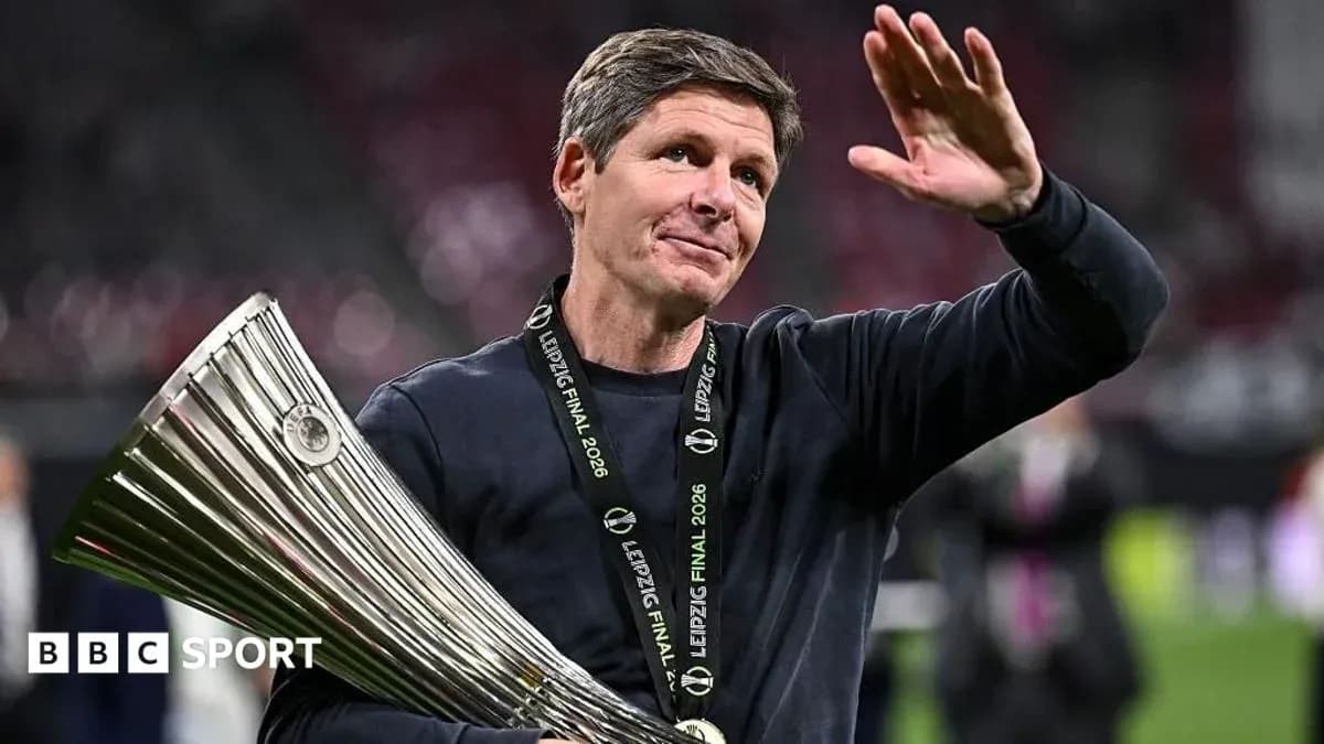 Coach holding trophy and waving to crowd