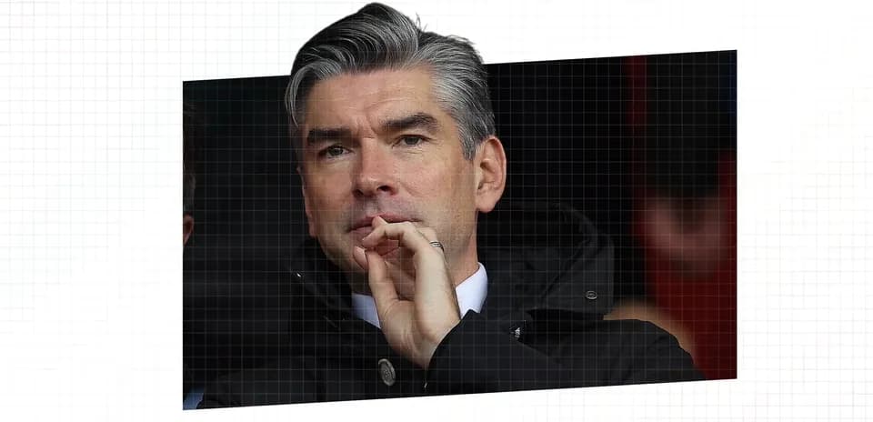 Man in a black jacket observing a match