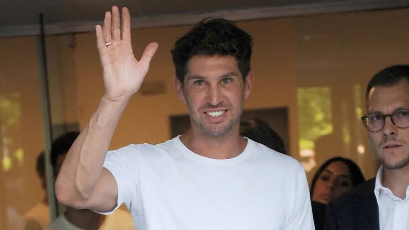 Man waving while standing near other individuals