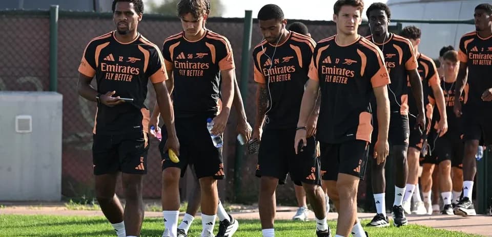 Arsenal players walking on training ground in kits