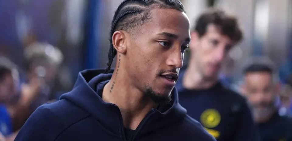 Player with braids walking through team area