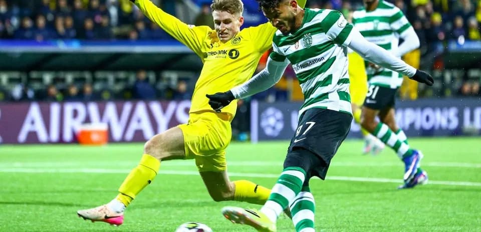 Sporting CP player kicking ball against opponent