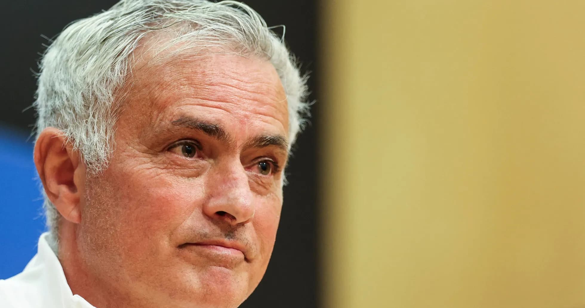 Coach speaking at press conference with serious expression