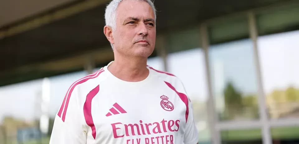 Coach in Real Madrid training kit on pitch