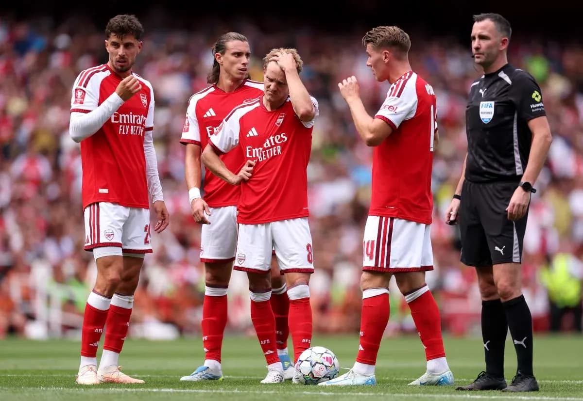 Arsenal players discussing strategy with referee