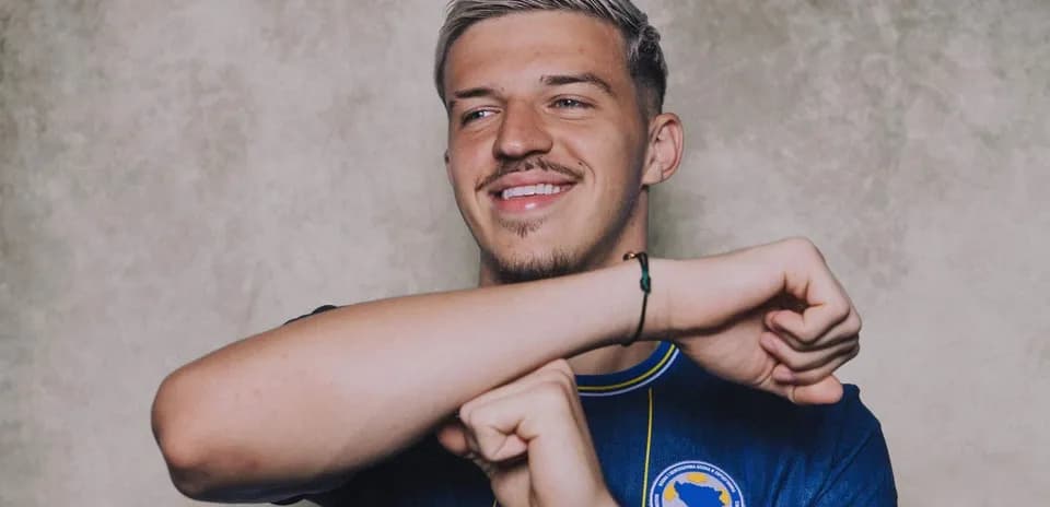 Player in blue jersey smiling and gesturing