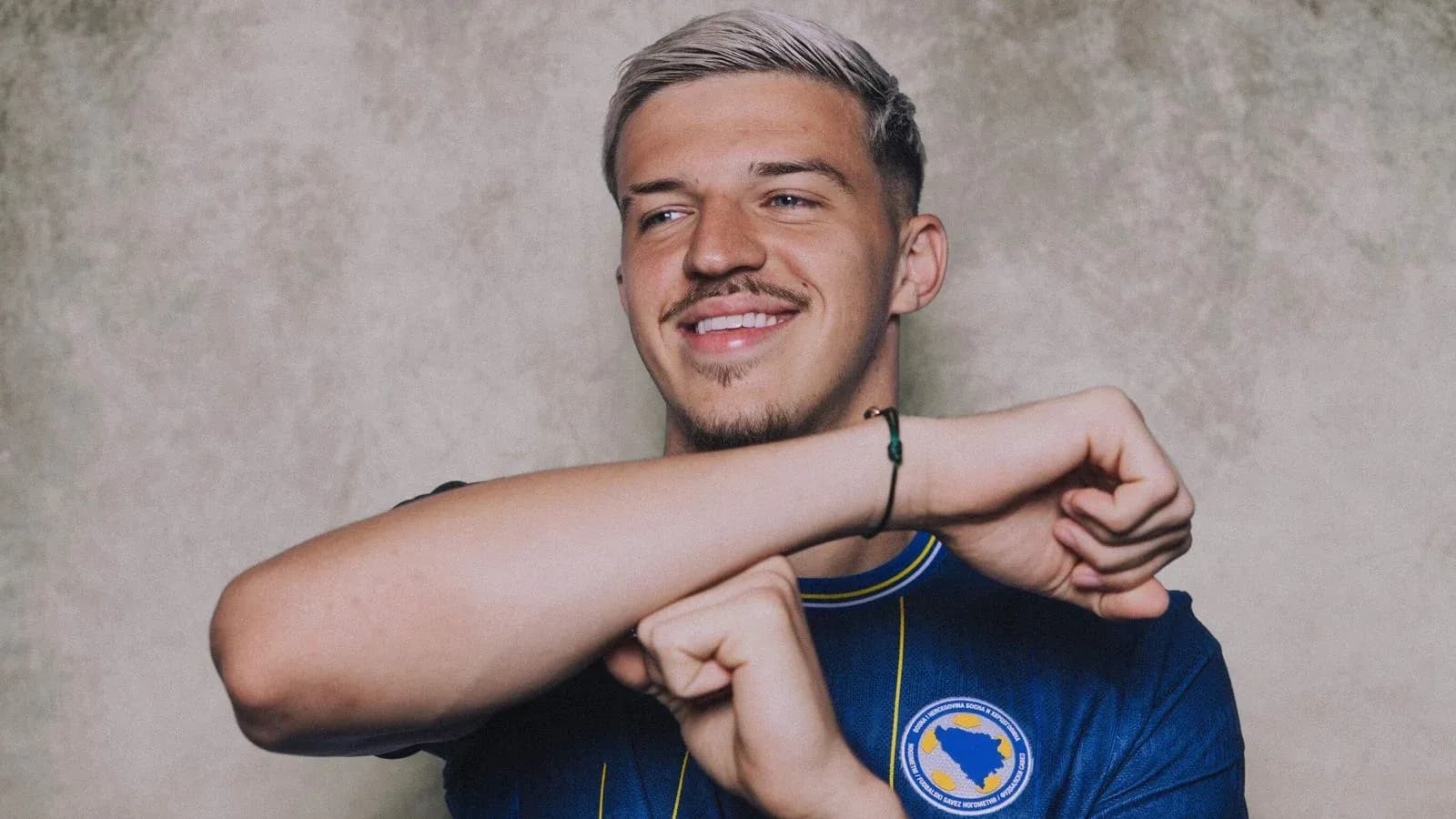 Player in blue jersey smiling and gesturing