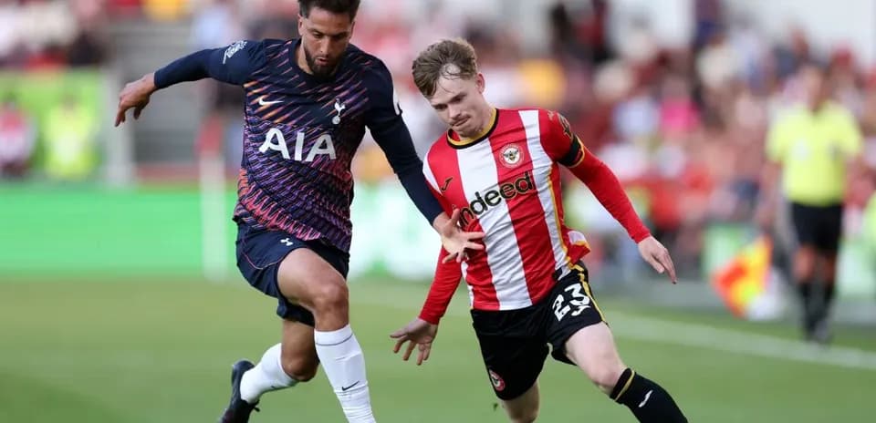Brentford player challenging Tottenham player for the ball