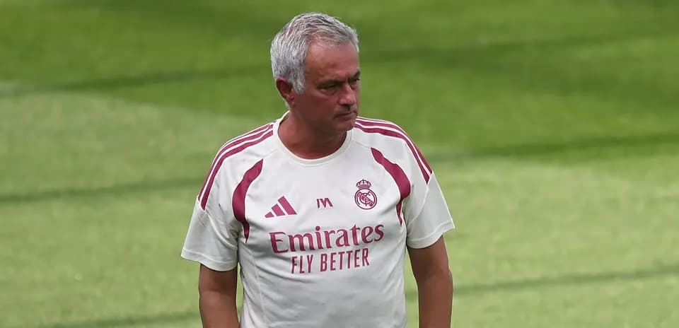 Coach walking on training pitch wearing team kit