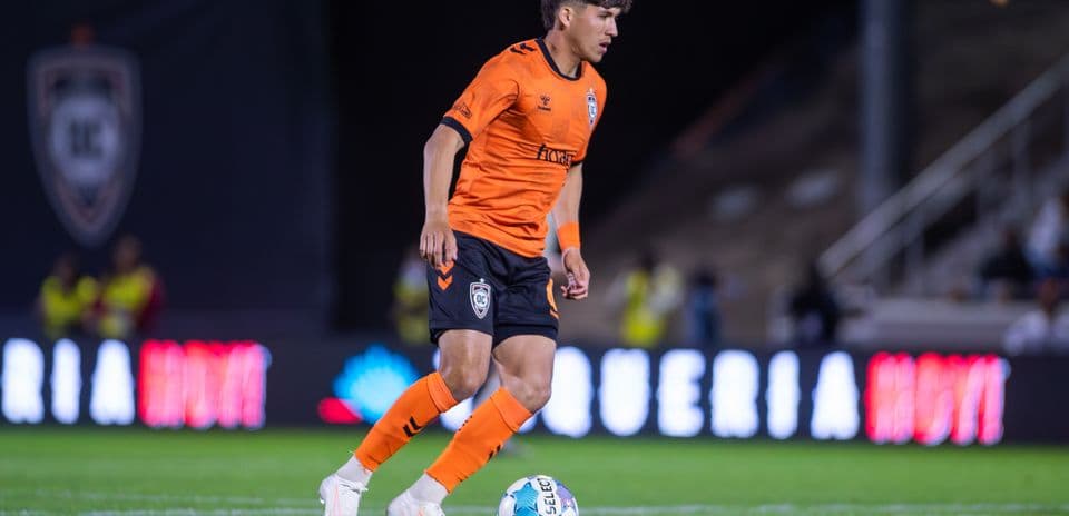 Orange County SC player dribbling ball on field