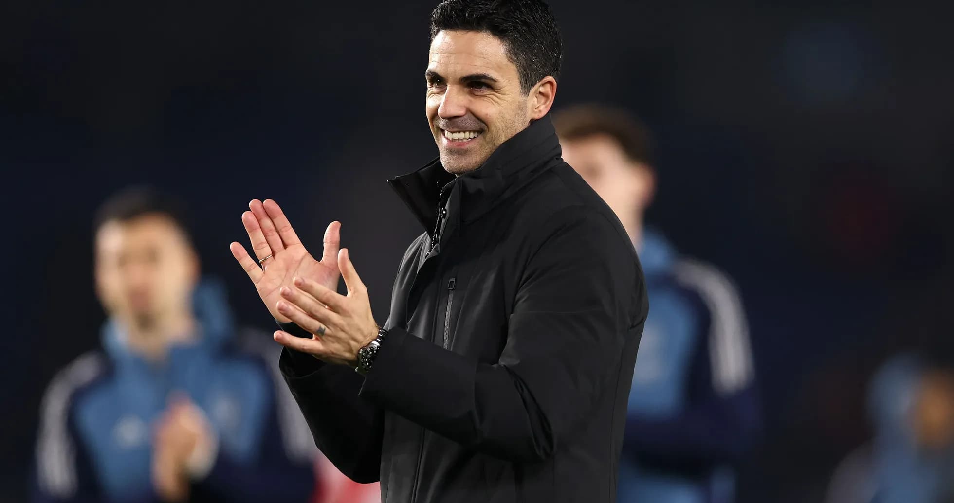 Manager clapping and smiling during a match