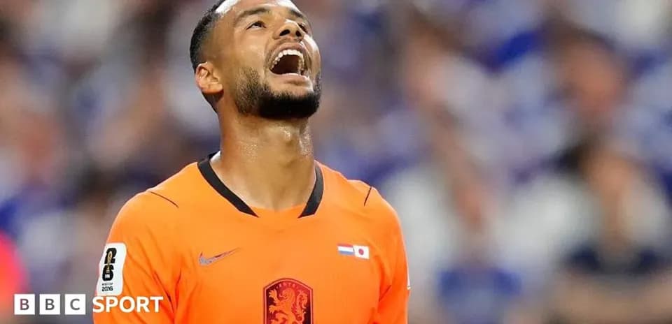 Goalkeeper in orange jersey reacting during match