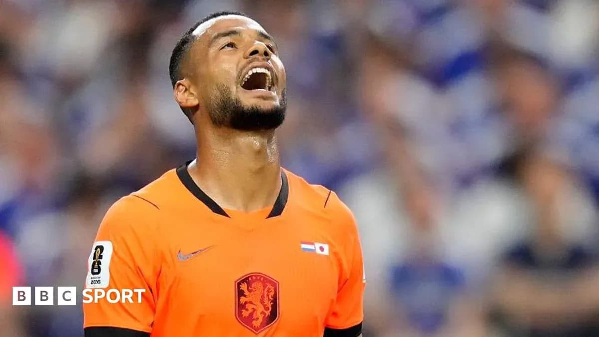 Goalkeeper in orange jersey reacting during match