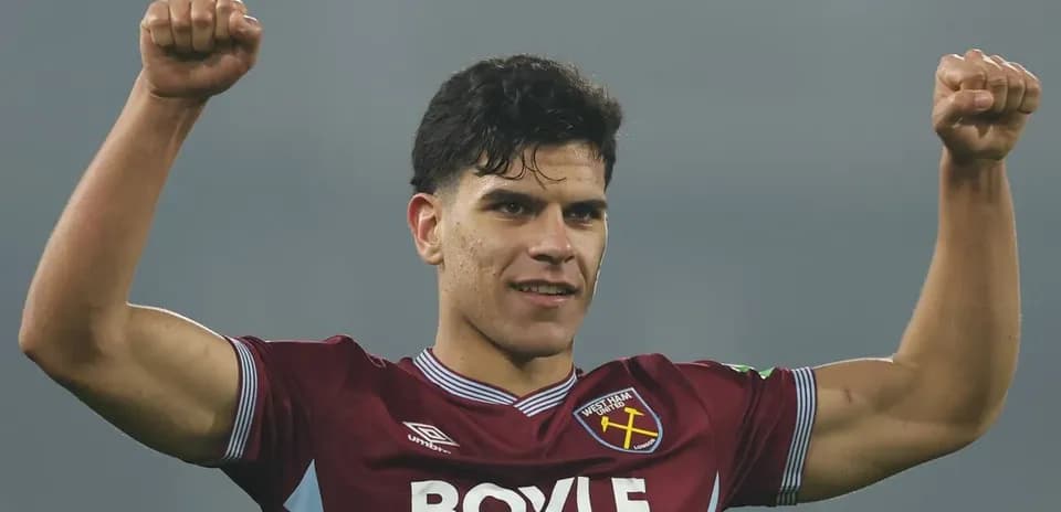 Player celebrating with raised fists in team jersey