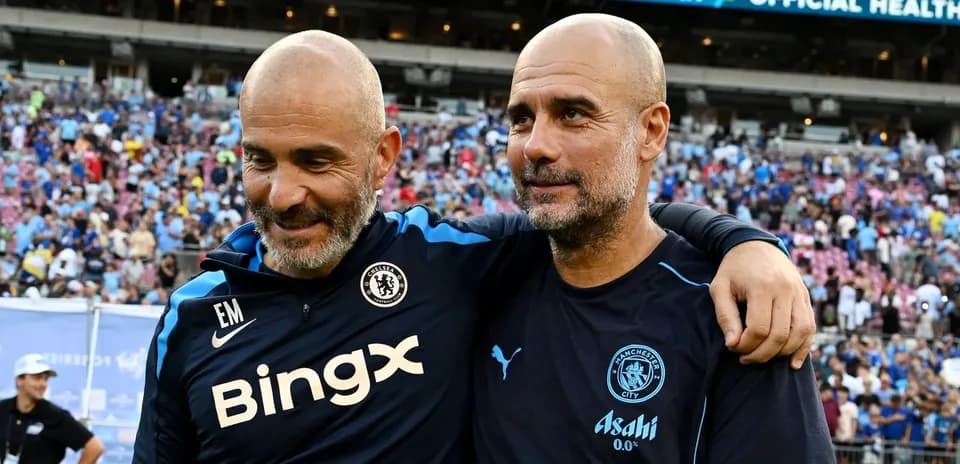 Two football managers smiling together on the field