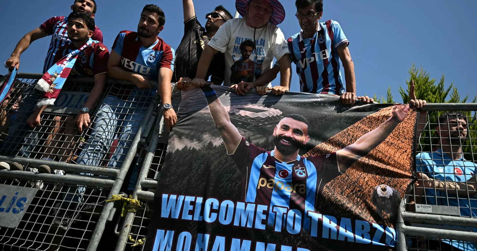Fans holding welcome banner for player in stadium