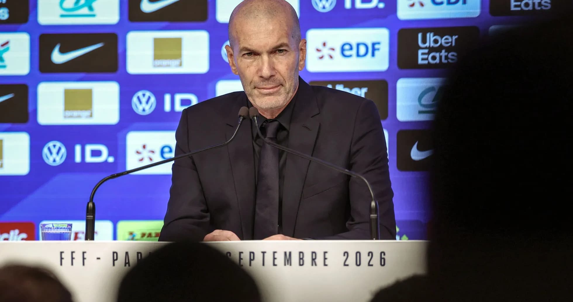 Manager at press conference with sponsor backdrop