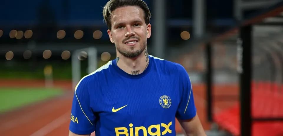 Player in blue Chelsea kit smiling on field