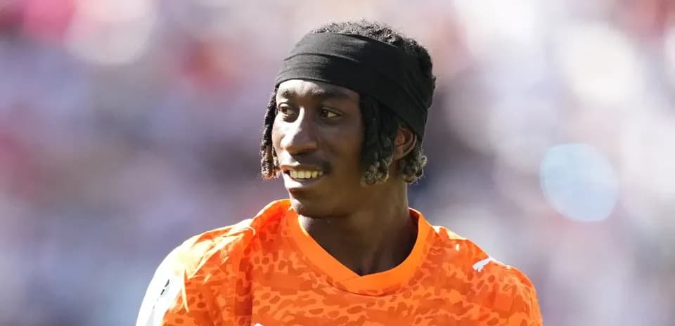 Goalkeeper in orange kit during warm-up session