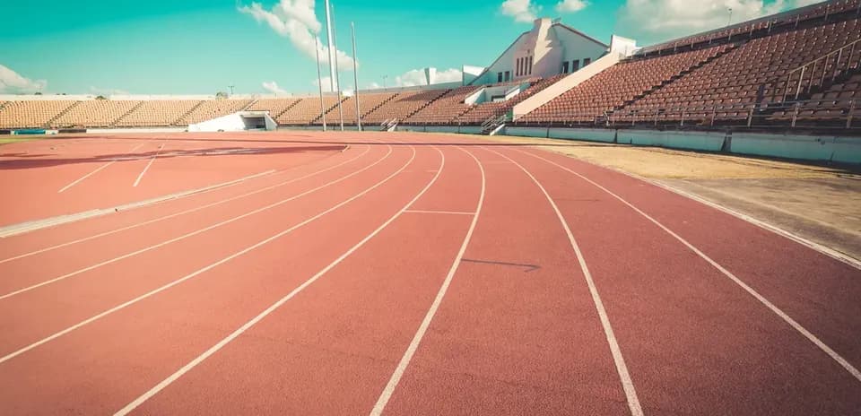 Empty athletic track with stadium seating in background