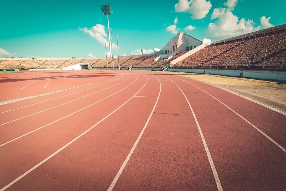 Empty athletic track with stadium seating in background