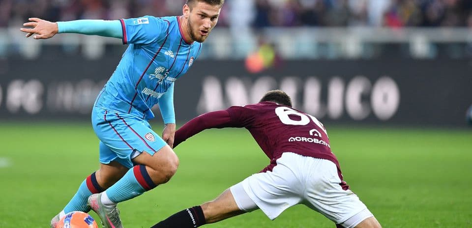 Cagliari player evading a Torino tackle