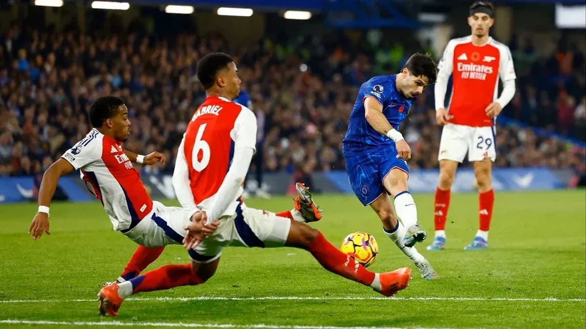Chelsea player shooting on goal against Arsenal defenders