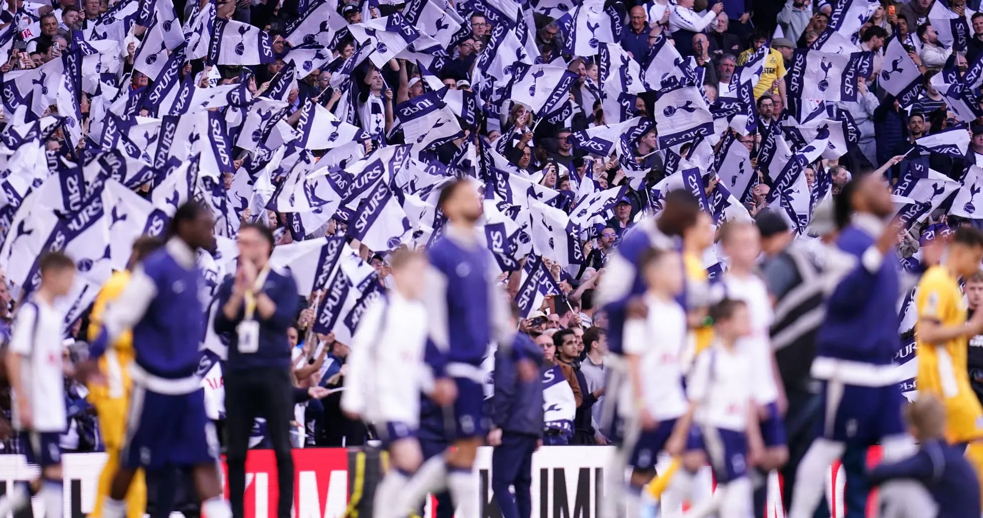 Fans waving flags during a Tottenham Hotspur match