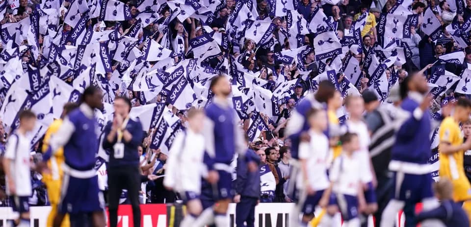 Fans waving flags during a Tottenham Hotspur match